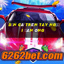 bắn cá trên tay người đàn ông